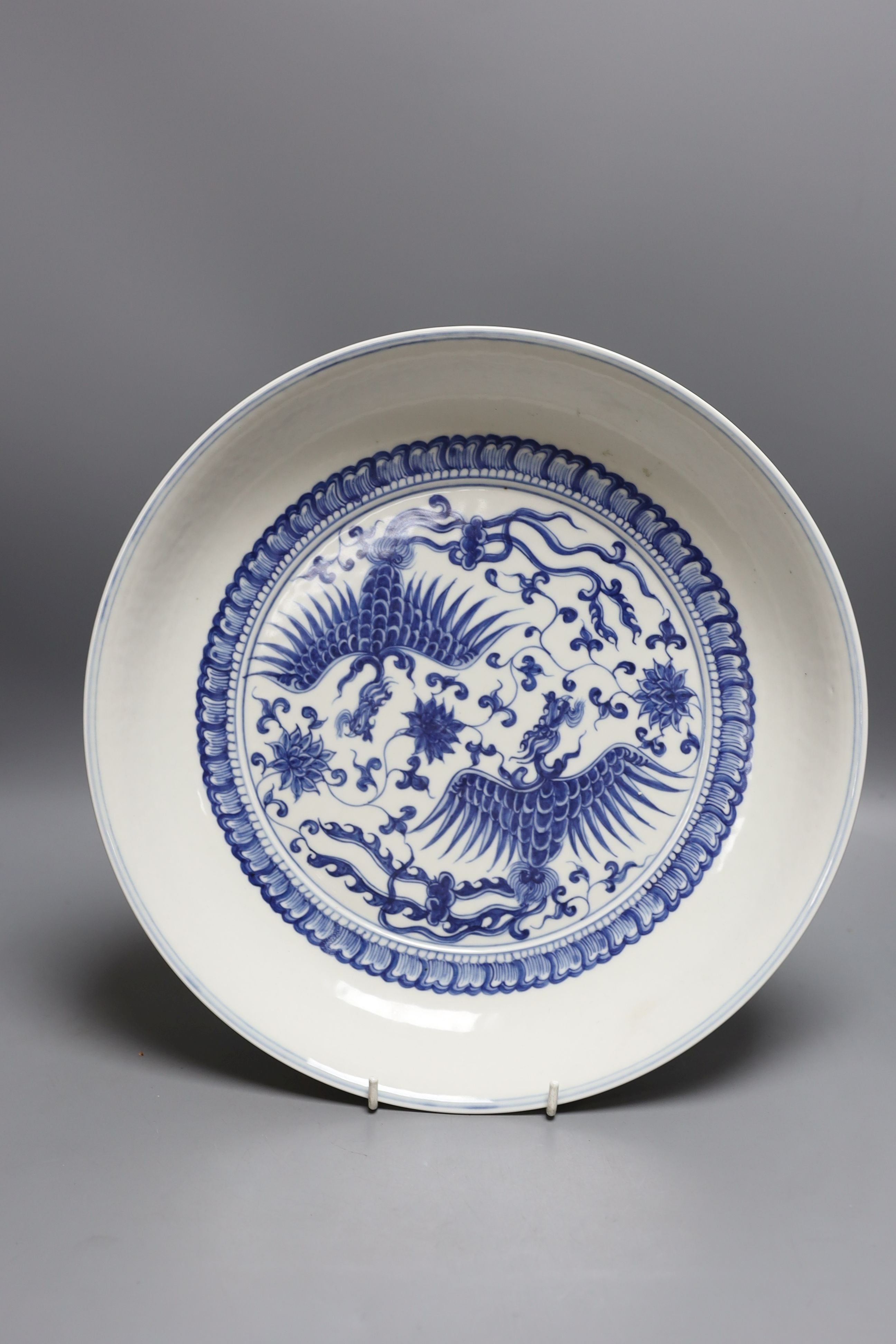 A 19th century Chinese blue and white celadon ground charger, marked to base, together with another blue and white Chinese charger (2)